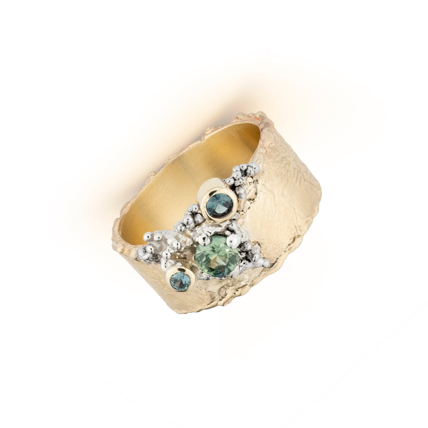 Gold ring with green sapphires on a white background