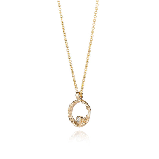 A delicate gold chain necklace featuring a textured, open circular pendant with a small diamond at its center, displayed against a solid white background.