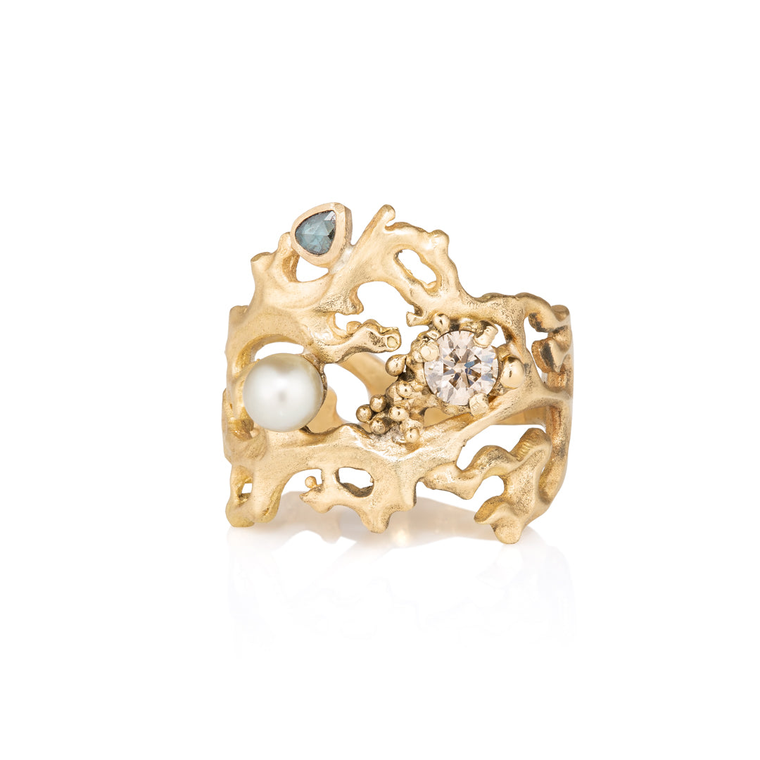 Yellow Gold ring with pearls and gemstones on a white background