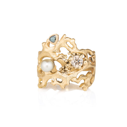 Yellow Gold ring with pearls and gemstones on a white background