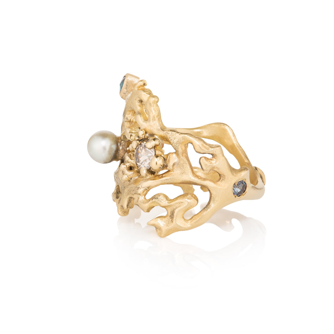 Yellow Gold ring with pearls and gemstones on a white background